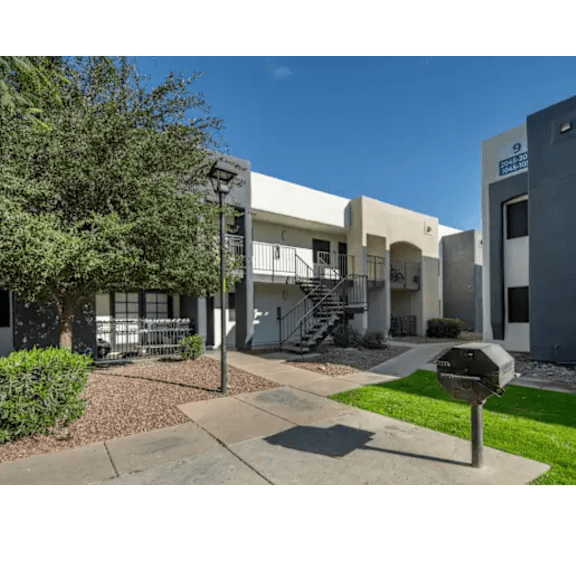 A sunny day at a residential area with apartment buildings and a mailbox.