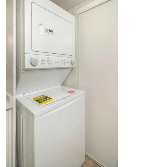 A white oven with a control panel on top and a sticker on the door.