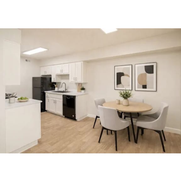 A kitchen with a table and chairs in the middle of the room.
