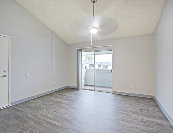 A room with a sliding glass door leading to a balcony.