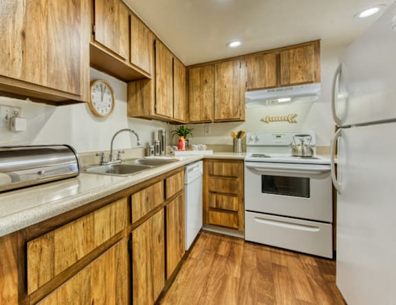 A kitchen with wooden cabinets and a white oven.