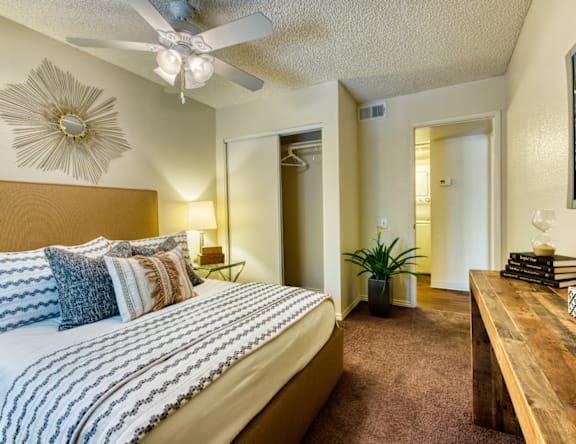 A bedroom with a large bed and a ceiling fan.