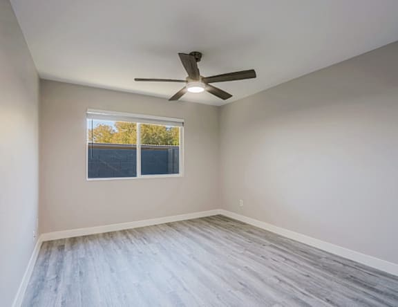 A room with a ceiling fan and a window.