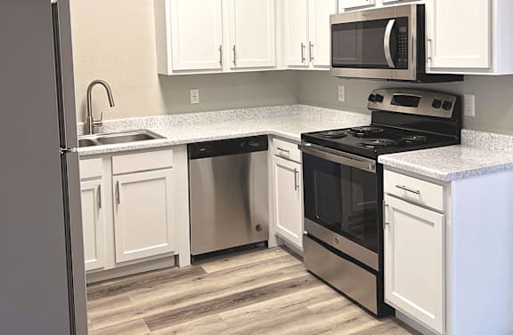 A kitchen with white cabinets and a black stove top oven.