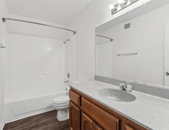 A white bathroom with a toilet, sink, and shower.