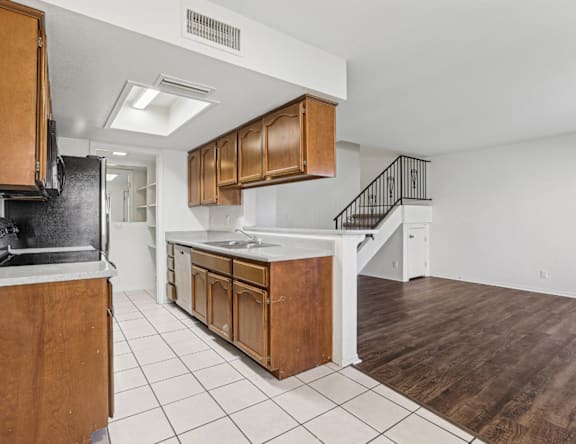 A kitchen with wooden cabinets and a black refrigerator.