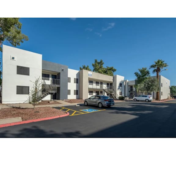 A white building with a parking lot in front of it.