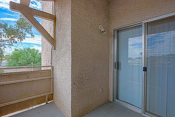 A balcony with a glass door and a window.