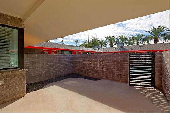 A red building with a black gate and a wall with a decorative design.