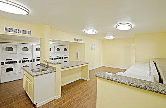 A kitchen with a counter and ovens.