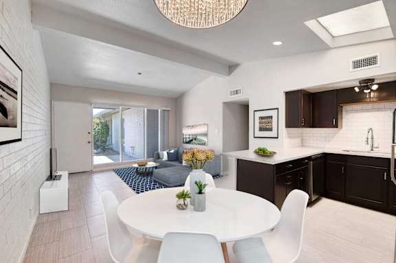 A modern kitchen with a dining table and chairs.