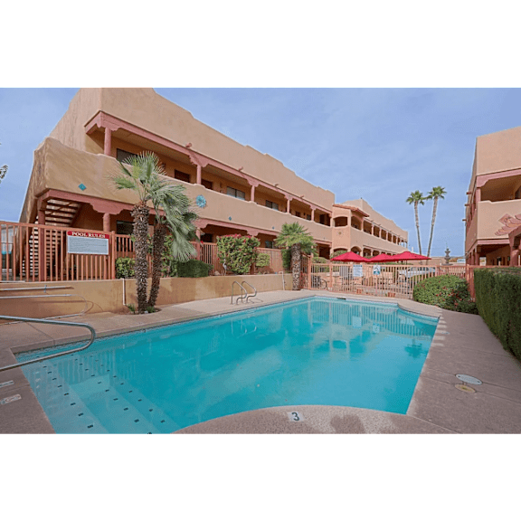 A large swimming pool is surrounded by a building.