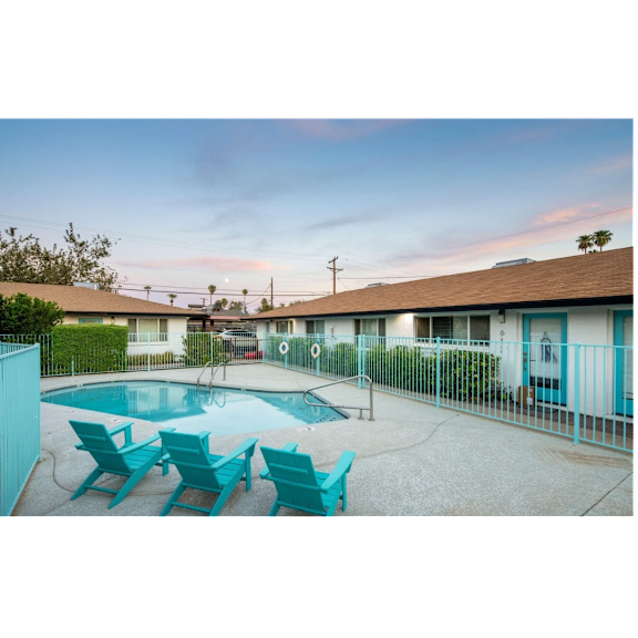 A pool surrounded by chairs and a fence.