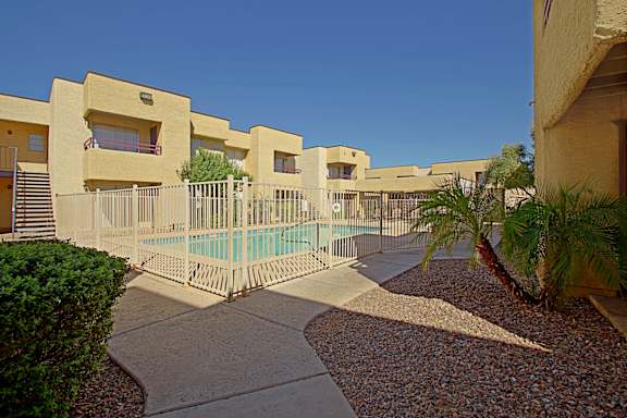 A row of houses with a pool in the middle.