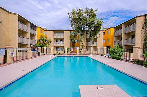 A swimming pool in front of apartment buildings.