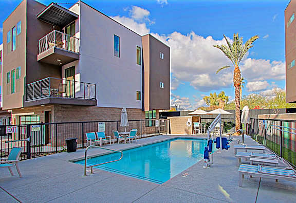 A pool area with a building in the background.