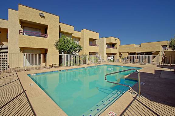 A swimming pool in front of apartment buildings.