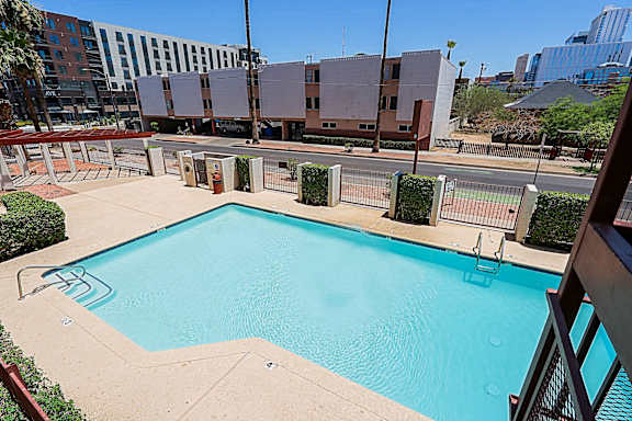 A swimming pool surrounded by a fence and buildings.