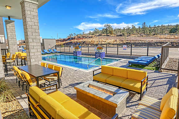 A poolside area with yellow seating and a table.