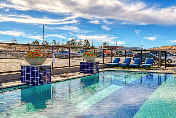 A pool with a blue tiled edge and a white ball on top of a blue tile block.