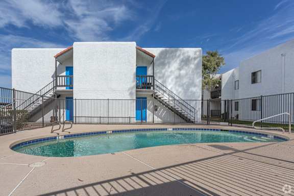 A white house with a pool in front.