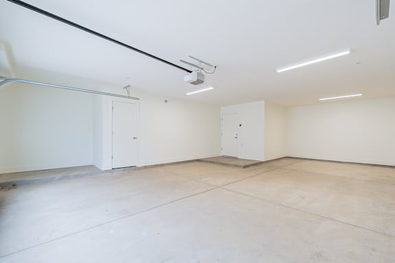 A large empty room with white walls and a concrete floor.