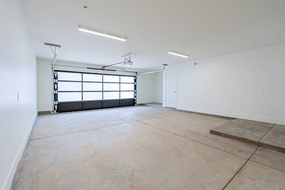 A large empty room with a window and concrete floor.