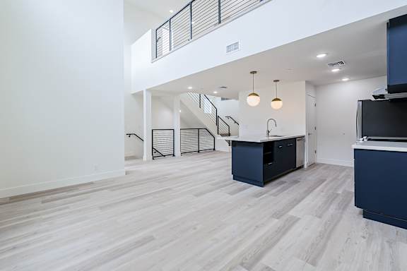 A spacious room with a staircase and a desk.