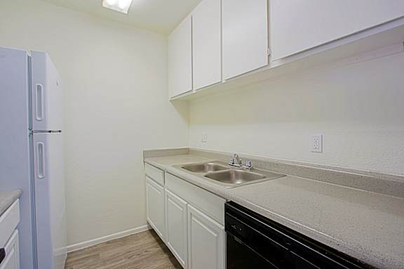 A kitchen with white cabinets and a black dishwasher.