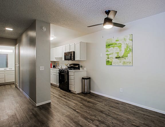 A kitchen with a refrigerator, microwave, and oven.