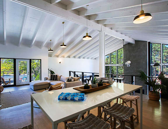 A modern dining room with a long table and chairs.
