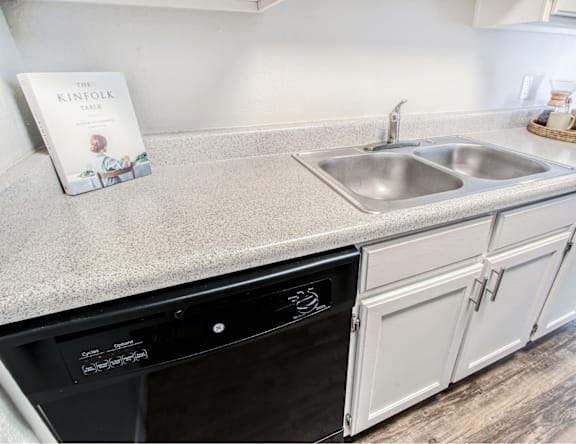 A kitchen counter with a book titled "The Kinfolk Table" on it.