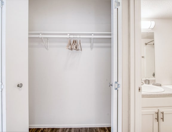 A white bathroom with a white door and a white sink.