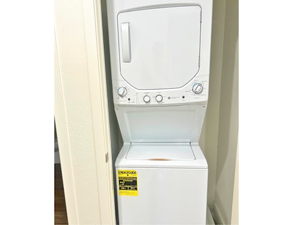 A white dryer is sitting in a doorway.