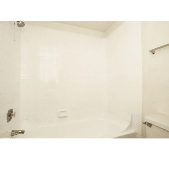 A white bathroom with a shower and a bathtub.