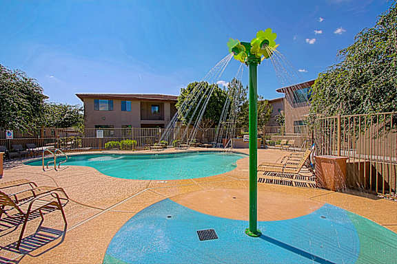 A water park with a green water spraying machine.