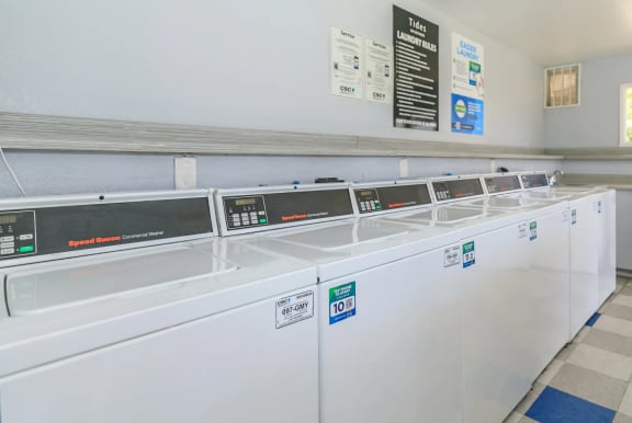 Laudry facilities with a row of washers at Tides on Southern in Mesa, Arizona