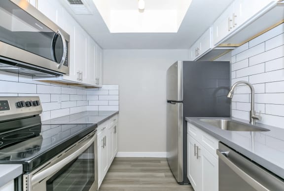 Upgraded kitchen with stainless steel appliances and white cabinets at Connect on Missouri in Phoenix, AZ