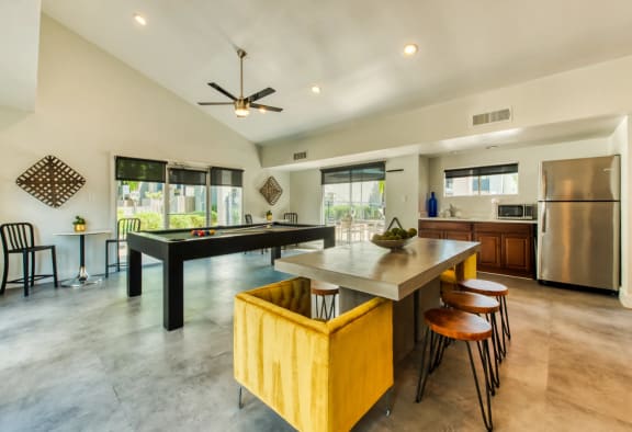 Resident clubhouse with lounge seating, a demo kitchen, and billiards table at Connect on Northern in Glendale, AZ
