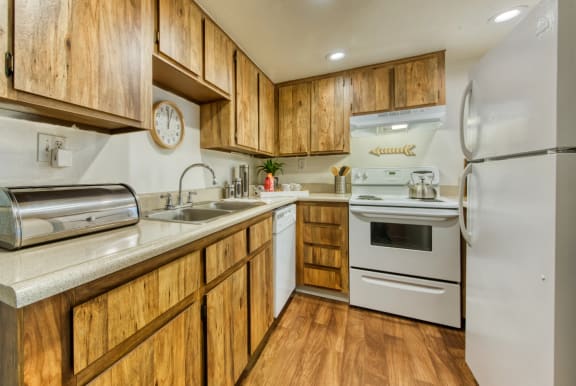 a kitchen with white appliances and wooden cabinets