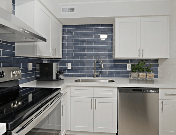 A kitchen with white cabinets and a black stove top oven.