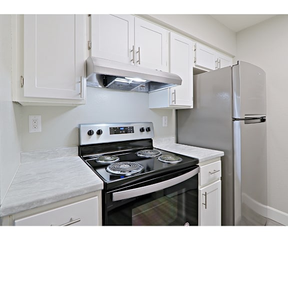 A kitchen with a stove and refrigerator.