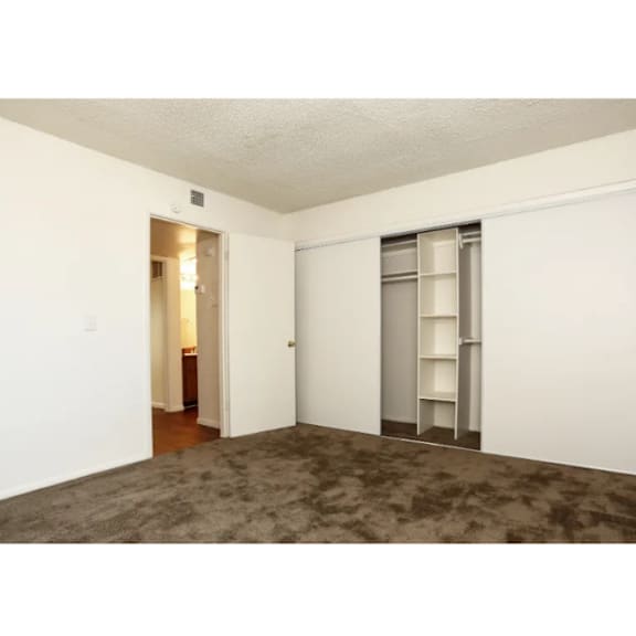 A room with a carpeted floor and a white door.