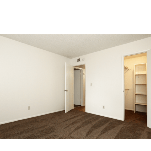 A room with a striped carpet and a white door.