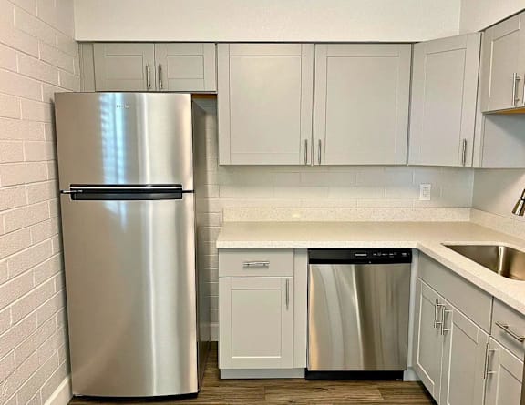 A kitchen with a stainless steel refrigerator and dishwasher.