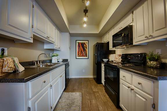A kitchen with black countertops and white cabinets.