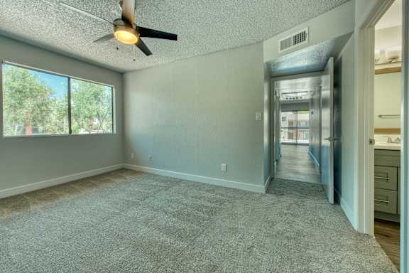 A room with a ceiling fan and a carpeted floor.