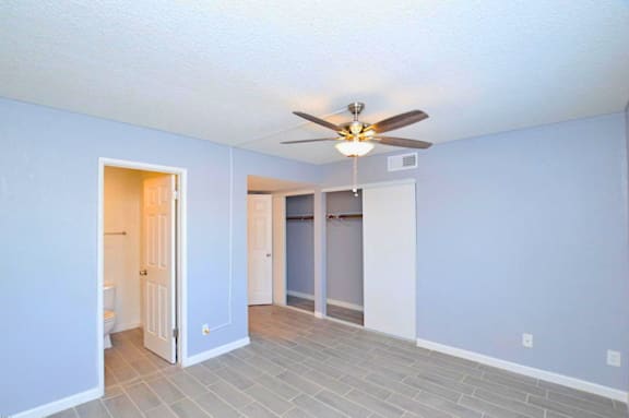 A room with a ceiling fan and tile flooring.