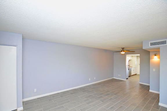 A room with a ceiling fan and a door on the left.