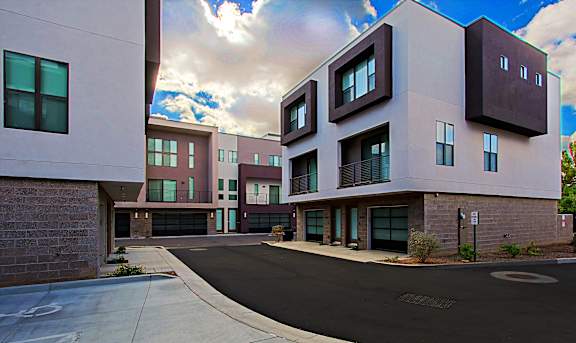 A modern building with a black driveway in front.